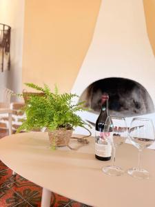 a bottle of wine and two glasses on a table at Putechella Slow Living Retrait in Tramonti