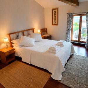 a bedroom with a bed with white sheets and a window at Gites de Source in Châtenet +31 photos