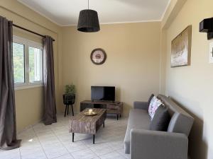 ein Wohnzimmer mit Sofa und Fernseher in der Unterkunft Konstantinos in Gythio