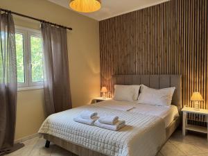 ein Schlafzimmer mit einem Bett, auf dem zwei Handtücher liegen in der Unterkunft Konstantinos in Gythio