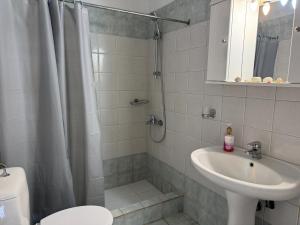 ein Badezimmer mit Dusche, Waschbecken und Toilette in der Unterkunft Konstantinos in Gythio + 15 Fotos