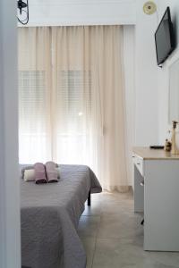 a bedroom with a bed with two pillows on it at Rodostagma 2 in Rodholívos