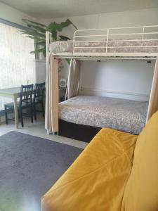 a bedroom with a bunk bed and a dining room with a table at Studio avec balcon proche des thermes in Saint-Paul-lès-Dax