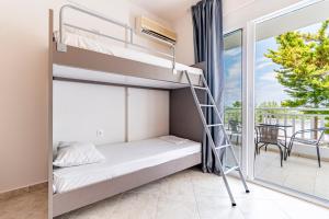 a bunk bed in a room with a balcony at Haris Hotel by Diomedes Group in Hanioti +61 photos