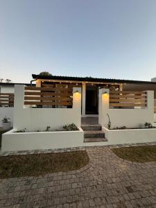 a house with white walls and a brick driveway at RElaxed city living in Port Elizabeth