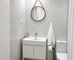 a white bathroom with a sink and a mirror at Abreu's Place in Câmara de Lobos +15 photos