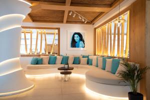 a living room with a white couch and blue pillows at Nikki Beach Resort & Spa Santorini in Kamari