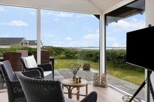 a screened in porch with a view of the ocean at LF12715-Vinderup-Vibevej-15 in Ejsingholm