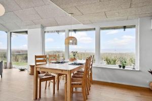 a dining room with a table and chairs and windows at LF12715-Vinderup-Vibevej-15 in Ejsingholm +25 photos