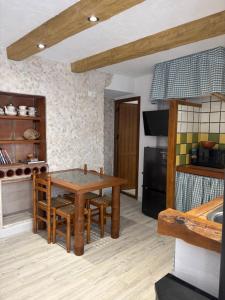 a kitchen with a wooden table and some chairs at Las Casitas de mi Abuela in Casares