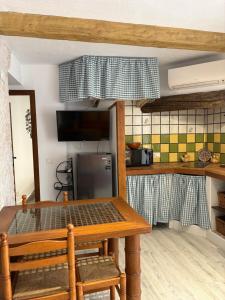 a kitchen with a wooden table and a kitchen with a counter at Las Casitas de mi Abuela in Casares