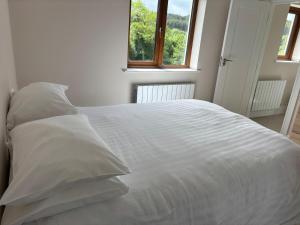 a white bed with white sheets and pillows in a bedroom at Lidia House in Westport