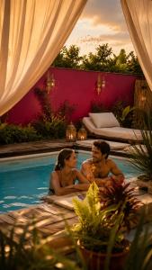 a man and woman sitting in a swimming pool at פלא - PELEH -KASHMIR -Quiet place 3 km from caesarea beach in Or ‘Aqīvāh