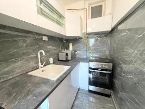 a kitchen with a sink and a stove at Beni Apartman in Szeged