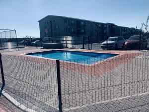 a fence around a swimming pool in a parking lot at The Penguin Nest in Gaborone
