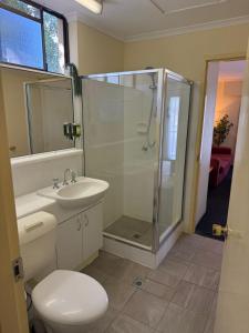 a bathroom with a shower and a toilet and a sink at Charming Suite Easy Access 2 CBD by Custom Bnb Hosting in Brisbane +15 photos