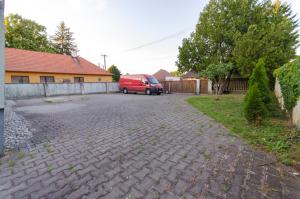 a red van parked in a driveway next to a house at Prízemný apartmán Anika s veľkým parkovaním in Nitra
