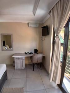 a room with a desk and a window at Jate Guest House in Maseru