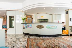 eine Lobby mit Rezeptionstresen und Teppich in der Unterkunft Hotel Touring in Caorle