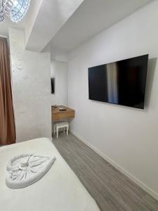 a bedroom with a bed and a flat screen tv at ND Central Apartment in Râmnicu Vâlcea