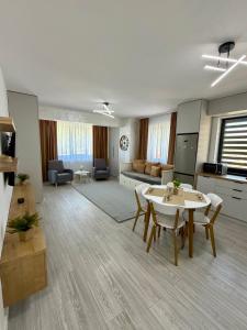 a large living room with a table and chairs at ND Central Apartment in Râmnicu Vâlcea +4 photos