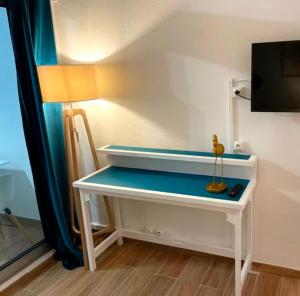 a white desk with a tv on top of it at Studio Calm Blue in Le Diamant