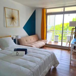 a bedroom with a large bed and a couch at Studio Calm Blue in Le Diamant +9 photos