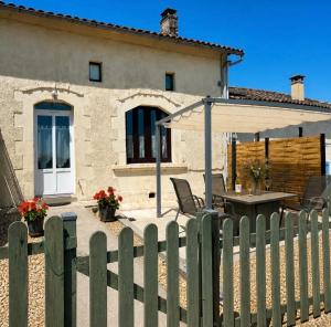 a wooden fence with a table and an umbrella at Gites de Source in Châtenet