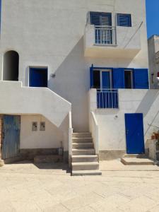 a white building with blue doors and stairs at Casa vacanze levanzo in Levanzo