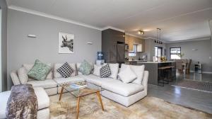 a living room with a couch and a kitchen at My Plett, Your Plett in Plettenberg Bay