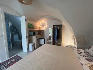 a bedroom with a bed and a kitchen in a room at La Dimora del Gigante in Carovigno