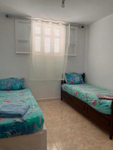 a bedroom with two beds and a window at Vacances El Haouaria in El Haouaria