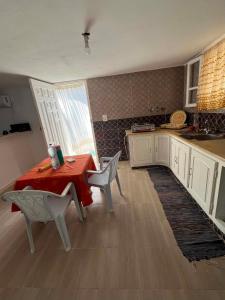 a kitchen with a table and two chairs and a table and a counter at Vacances El Haouaria in El Haouaria