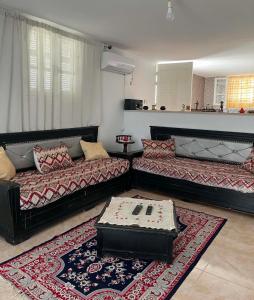 a living room with two couches and a rug at Vacances El Haouaria in El Haouaria +4 photos