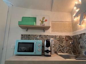 a kitchen counter with a microwave and a sink at La Dimora del Gigante in Carovigno
