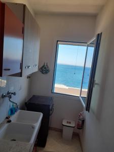 a bathroom with a sink and a window overlooking the ocean at Casa vacanze levanzo in Levanzo +7 photos