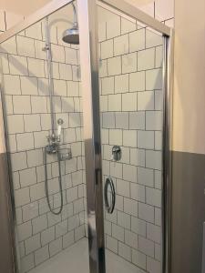 a bathroom with a shower with white tiled walls at Le 3 Rane B&B in Treggiaia