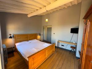 a bedroom with a wooden bed and a desk at Le 3 Rane B&B in Treggiaia