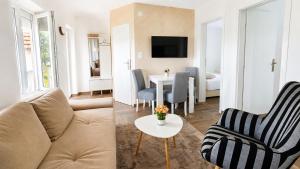 a living room with a couch and a table at Danube Panorama House - River View, Jacuzzi & Nature in Čelarevo