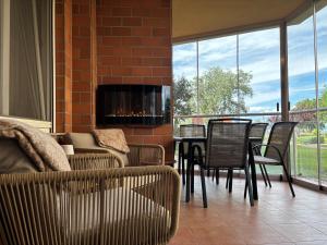 a living room with a table and chairs and a fireplace at BALA Resort Apartman in Siófok