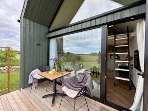 a garden room with a table and chairs on a deck at Greencabin - Cabin Escape in the Heart of Saaremaa in Pamma