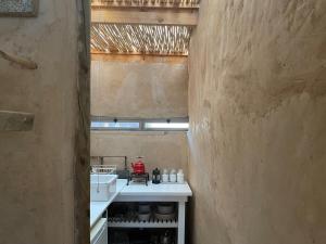 a kitchen with a white counter and a sink at Strooi Kooi - Unique Strawbale Cottage in Calitzdorp