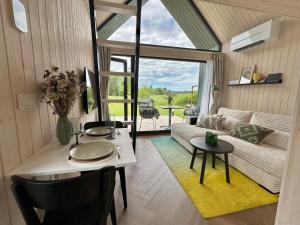a living room with a couch and a table at Greencabin - Cabin Escape in the Heart of Saaremaa in Pamma