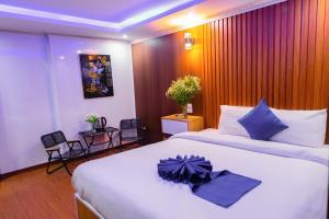 a hotel room with two beds and a table and chairs at Sa Pa Camellia Hotel in Sapa