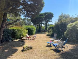 a group of chairs and a table in a yard at Chambre à louer face a la plage de Beaumer in Carnac