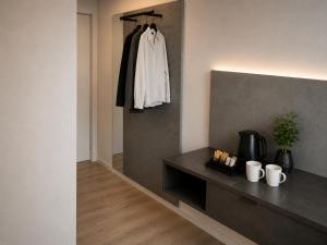 a room with a black counter and a white shirt hanging on a wall at SleepySleepy Hotel Fulda in Fulda