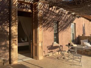 a patio with a table and chairs next to a building at Strooi Kooi - Unique Strawbale Cottage in Calitzdorp +24 photos