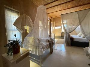 a bedroom with a bed with a veil on it at Strooi Kooi - Unique Strawbale Cottage in Calitzdorp