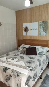 a bedroom with a bed with a comforter on it at POUSADA MEGA in Marataizes