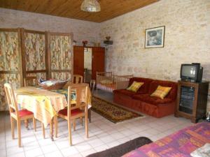 a living room with a red couch and a table at Gite de la Maison Noble in Champagné-le-Sec